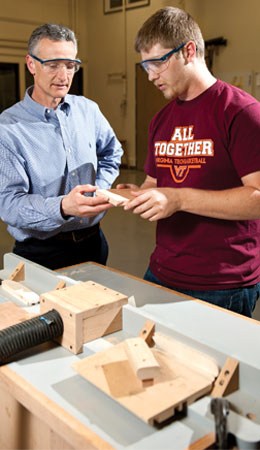 Professor Earl Kline and student Josh Hertzler talk inside the Thomas M. Brooks Forest Products Center. Photo by Logan Wallace.