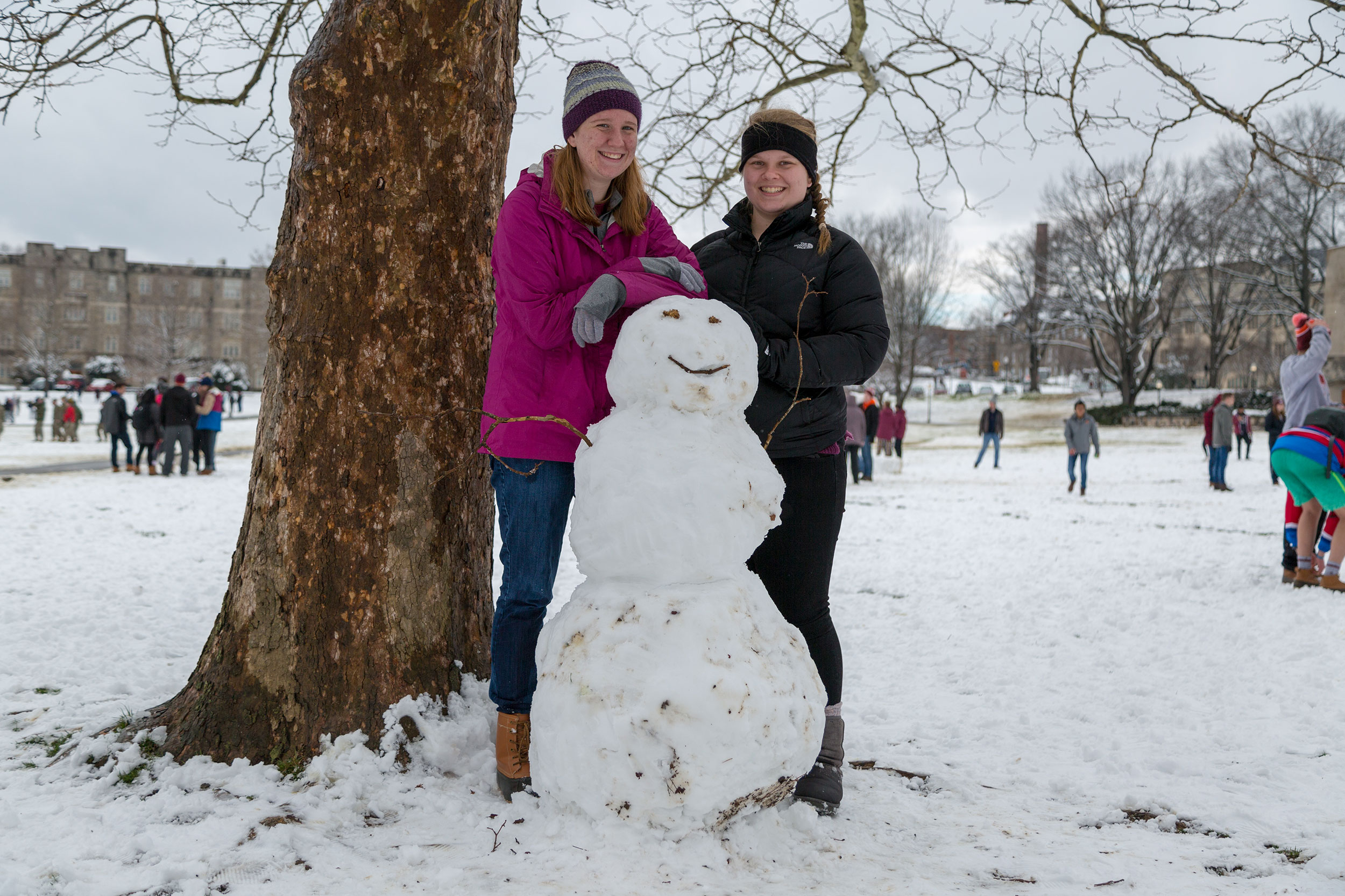 Sophomore MSE major Allison Slomniski (left) and sophomore Jessica Harris pose with their snowman they built on the Drillfield.